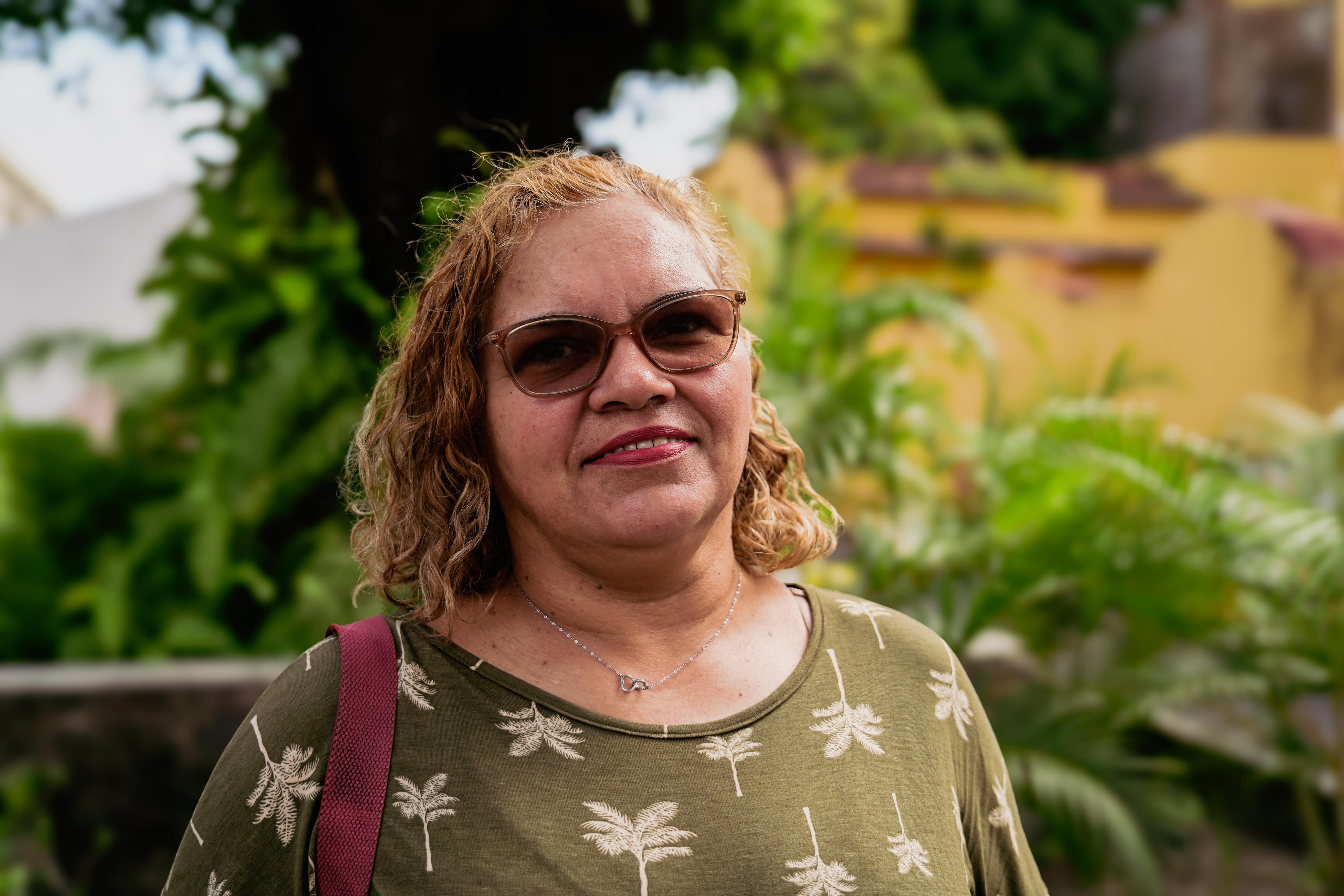 Elisangela Rodrigues é mulher loura, branca, usa óculos e veste uma blusa verde